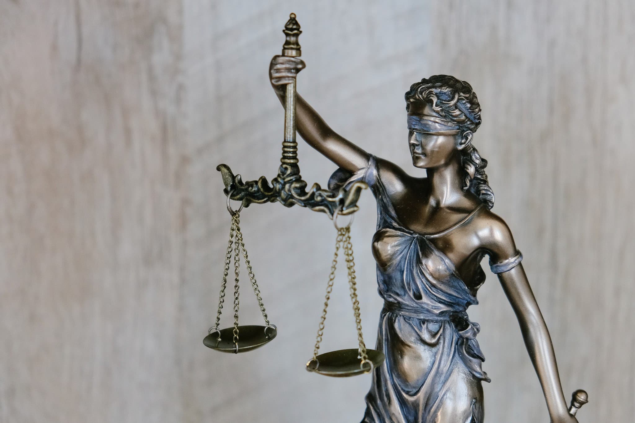 Bronze Lady Justice statue holding balanced scales